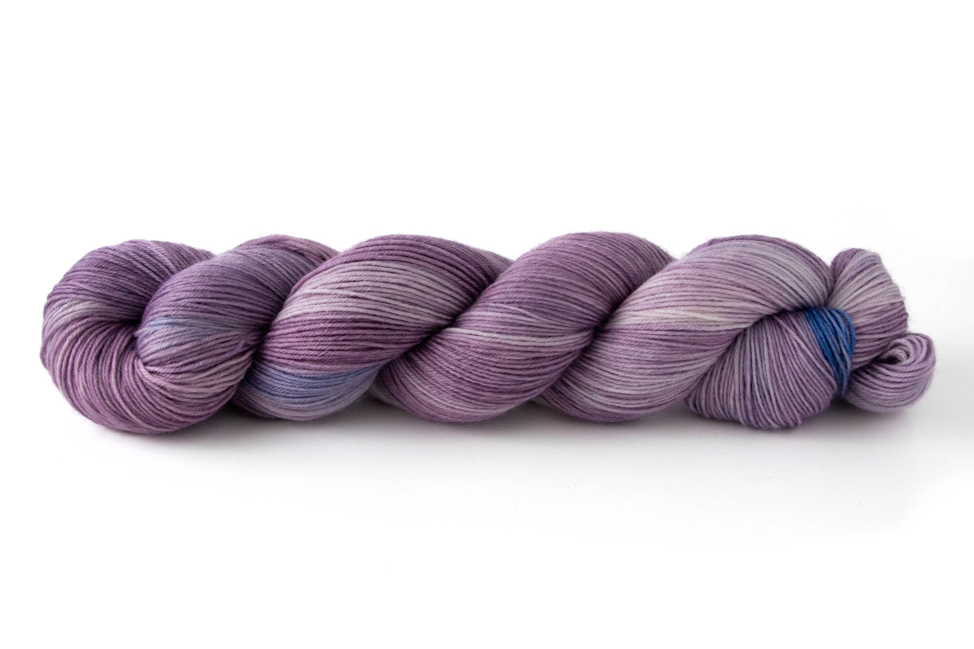 A skein of purple tonal hand-dyed wool yarn with blue highlights.