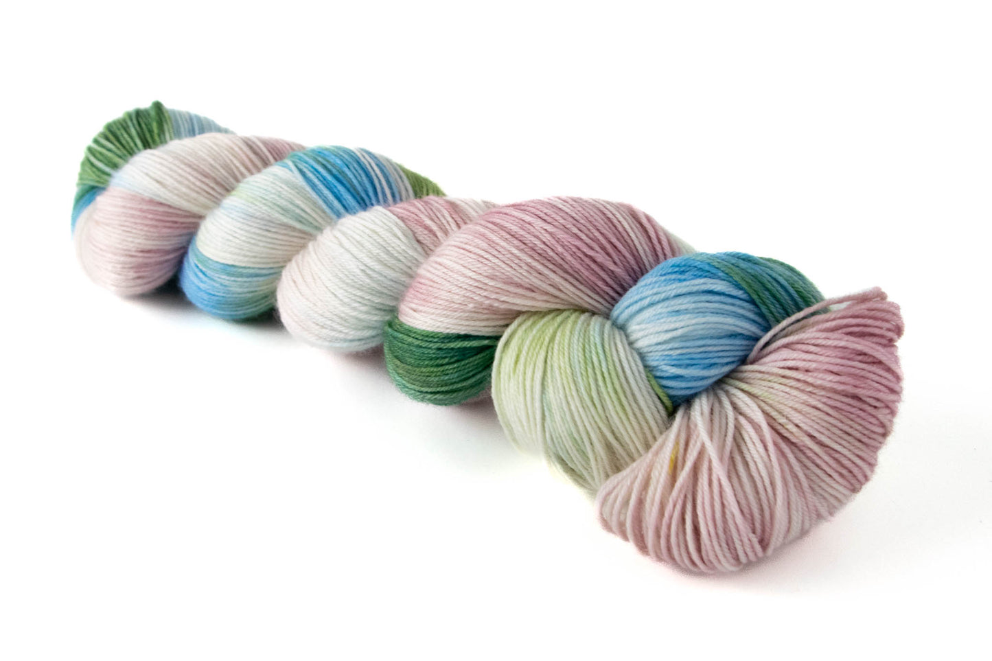 A skein of variegated green, blue, pink, and white hand-dyed wool yarn.