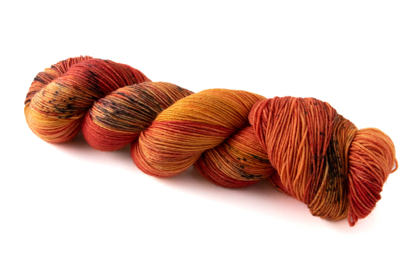 A skein of saturated red and orange variegated hand-dyed wool yarn with black speckles.