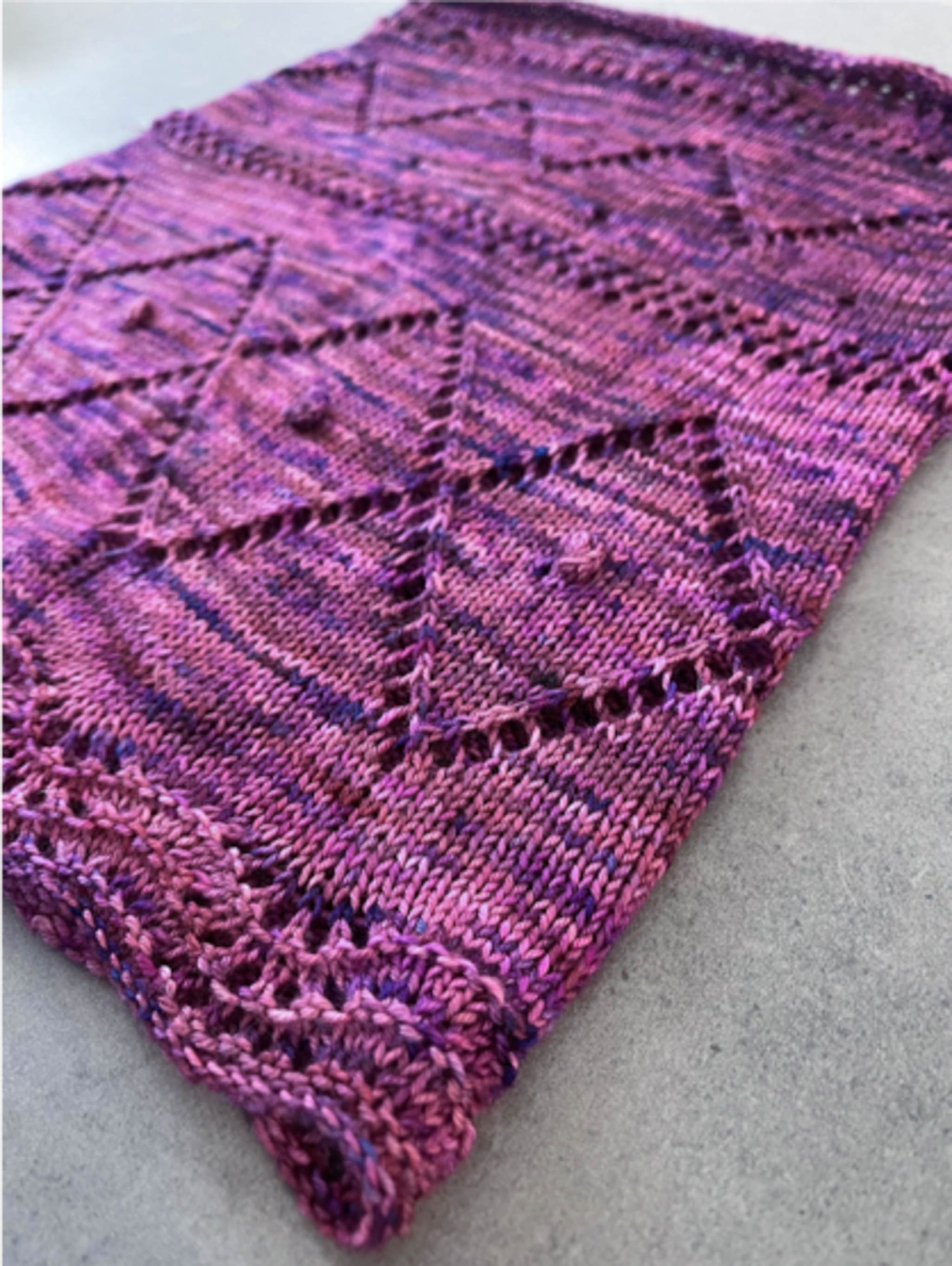 The Gillian knit cowl in Practical Magic colorway, a purple and pink variegated.