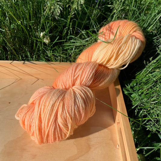 A skein of yellow and orange hand-dyed yarn.