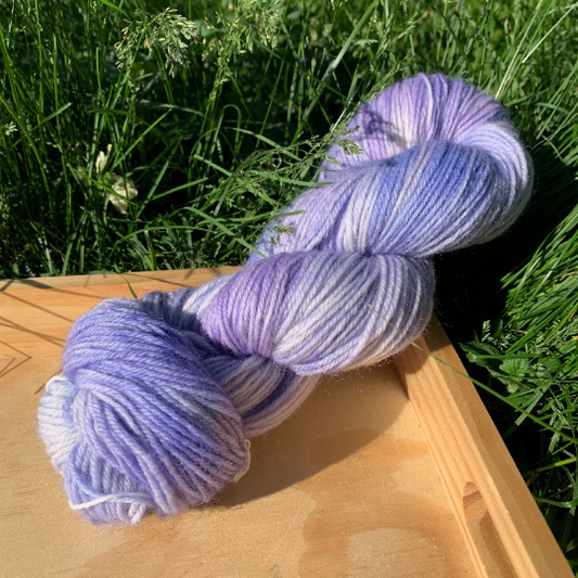 A tonal purple and blue skein of hand-dyed yarn.